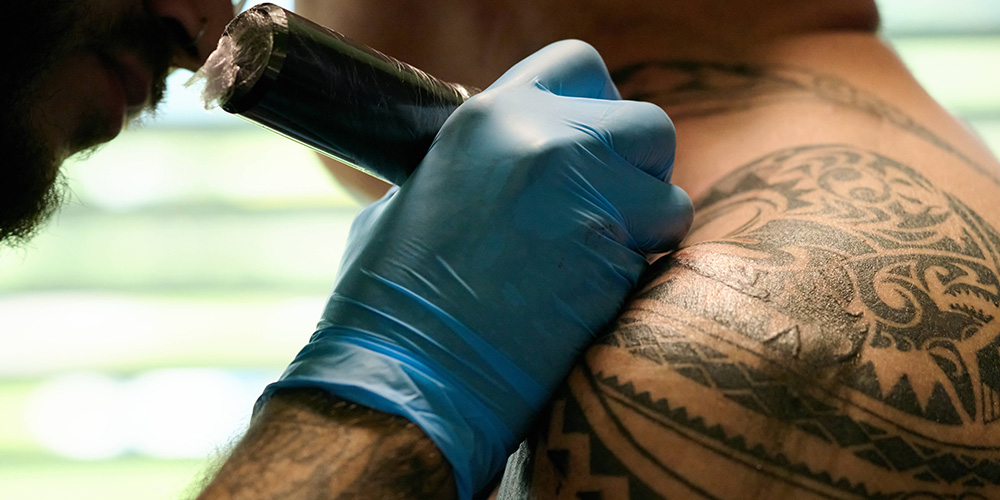 Bei einem Mann wird die Schulter tätowiert